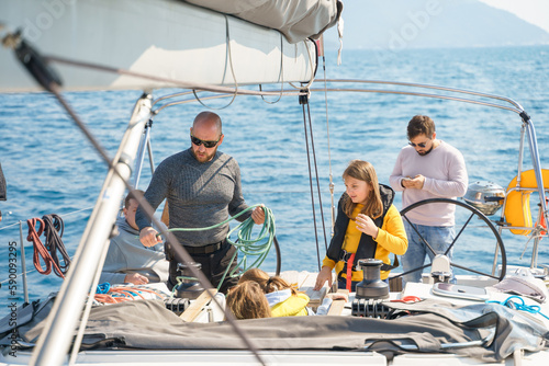 Voyage sail on sport sea luxury yacht. Yachting family summer vacation cruise. Children, sailor kid girl sailing in little safe life jacket. Ocean ship boa travel. Enjoy trip on sailboat front deck