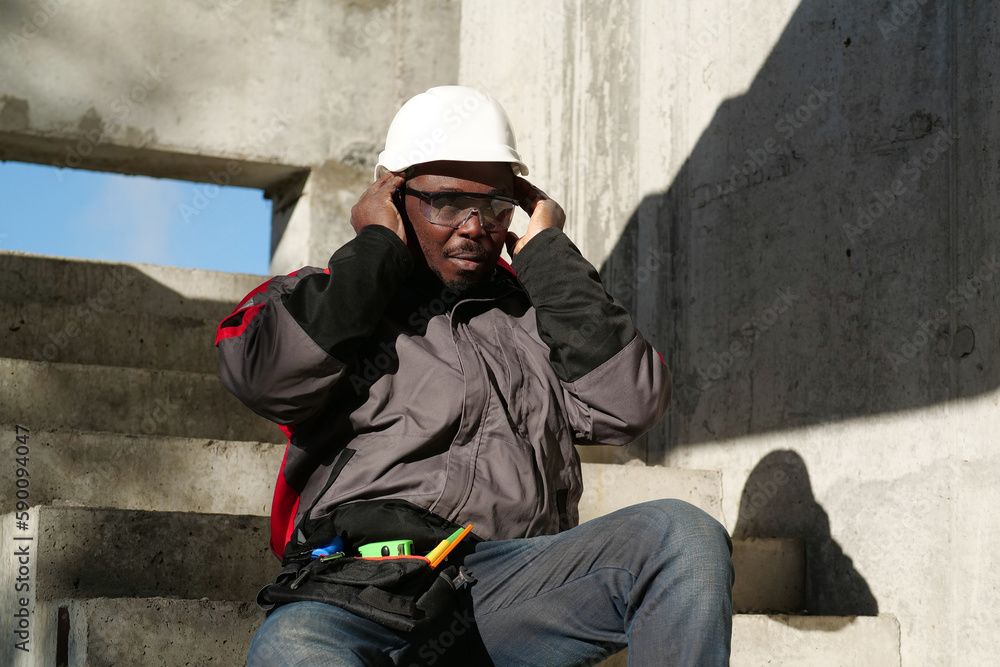 African american worker at project site has headache, he touches his head African american worker at project site has headache, he touches his head