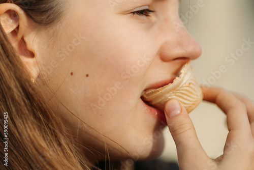 Close up of young girl's face eating waffle cup, side view