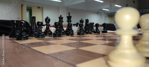 Wooden chessboard with chess pieces on it. Wooden chess board with chess pieces. photo