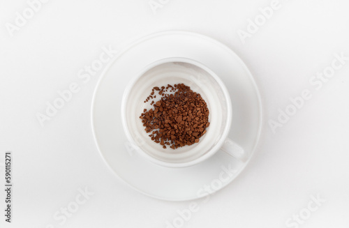 A white cup with instant coffee on a white background. Blank cup. Top view.