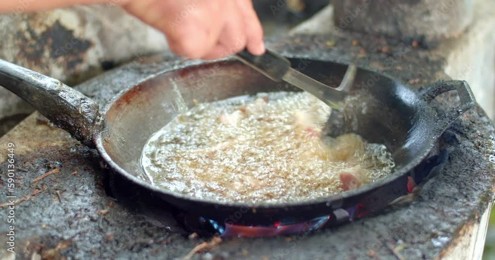 One sun-dried pork in Thailand is popular to cook and eat.Close-up of fried pork in old pan and hot oil from top view. One sun-dried pork in Thailand is popular to cook and eat.Close-up of fried pork in old pan and hot oil from top view.