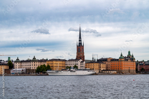 Stockholm, Sweden - Panorama of old town Gamla Stan with church and tower. Waterfront with old houses and boats.