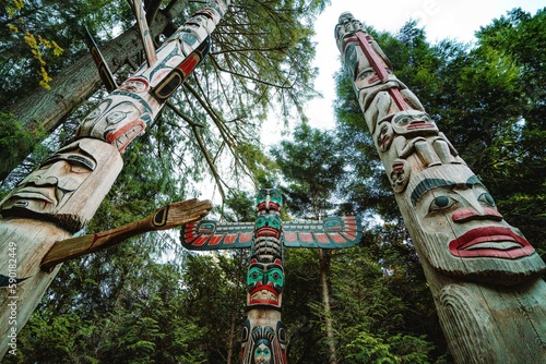 wide shot of large totems with many colors and intricate designs during the day at cultural center in vancouver