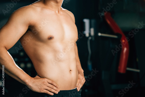 A muscular man in his underwear, standing with a confident and sexy attitude, showcases his toned body and bicep muscles for a fitness advertisement. Healthy fitness Lifestyle with copy space