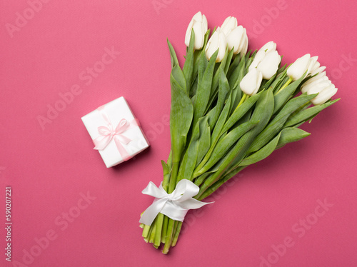 White tulip bouquet and gift box on color background  top view