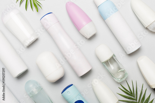 Many different deodorants on color background, top view
