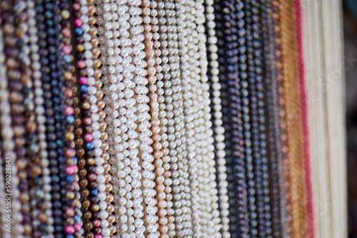 Handmade Strands of Assorted Pearl Necklaces hanging on a Rack