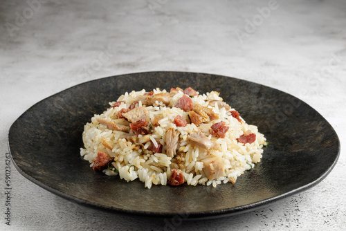 Rice dish with pieces of shank and bacon.