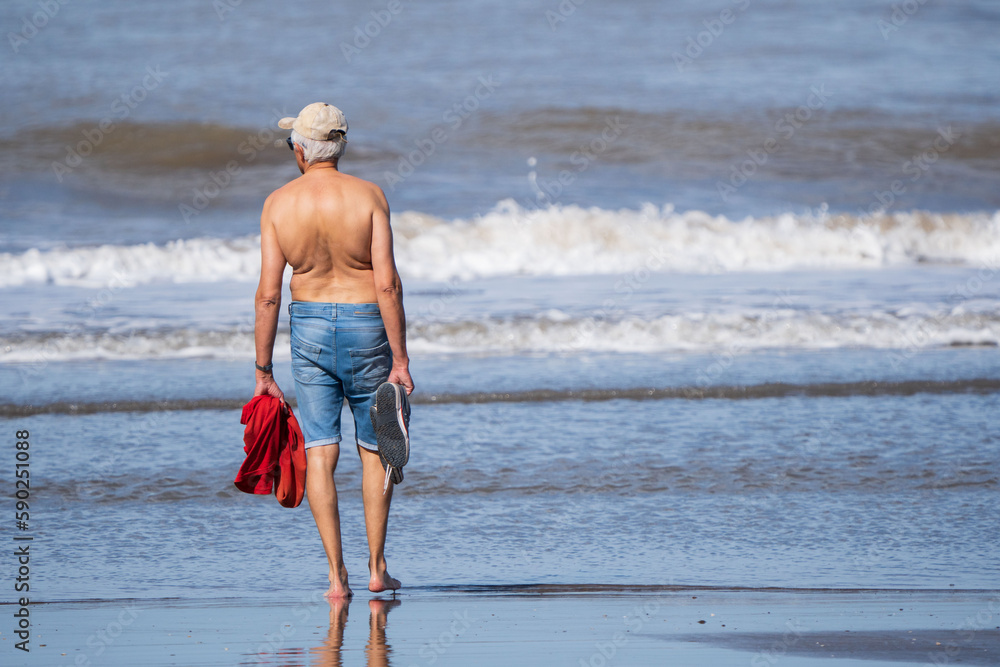 Elderly man on his back looking at the sea, unconcerned.