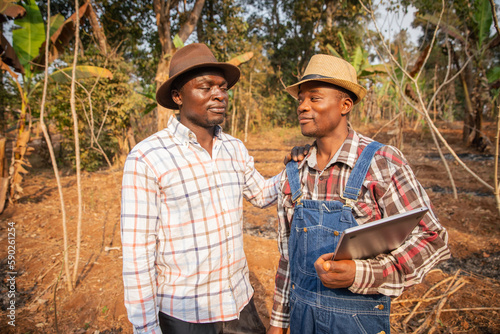 Fotografie Two farmers negotiating in a field, agriculture in Africa