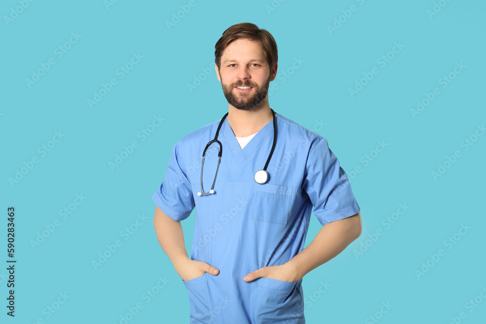 Happy doctor or medical assistant (male nurse) with stethoscope on turquoise background Happy doctor or medical assistant (male nurse) with stethoscope on turquoise background