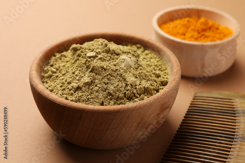 Comb, henna and turmeric powder on beige background, closeup. Natural hair coloring