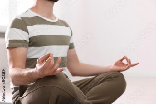 Closeup view of man meditating indoors, space for text