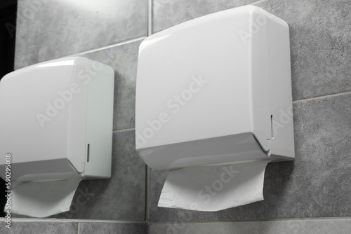 Fotografía New paper towel dispenser hanging on wall near mirror in bathroom