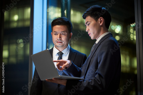 Photography two asian businessmen discussing business in office using laptop computer