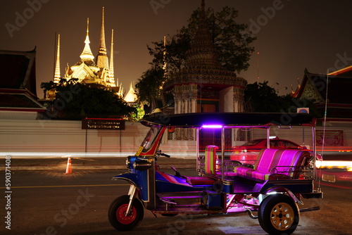 Photography Tricycle in Bangkok city Thailand is known as a tuk tuk with the backdrop of the Wat Pho pagoda