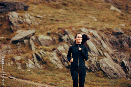 Athletic Woman Running and Training on a Mountain Trail. Active runner staying in shape running on rocky mountains  