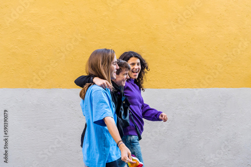 Young diverse friends walking on the street with pride rainbow flag.