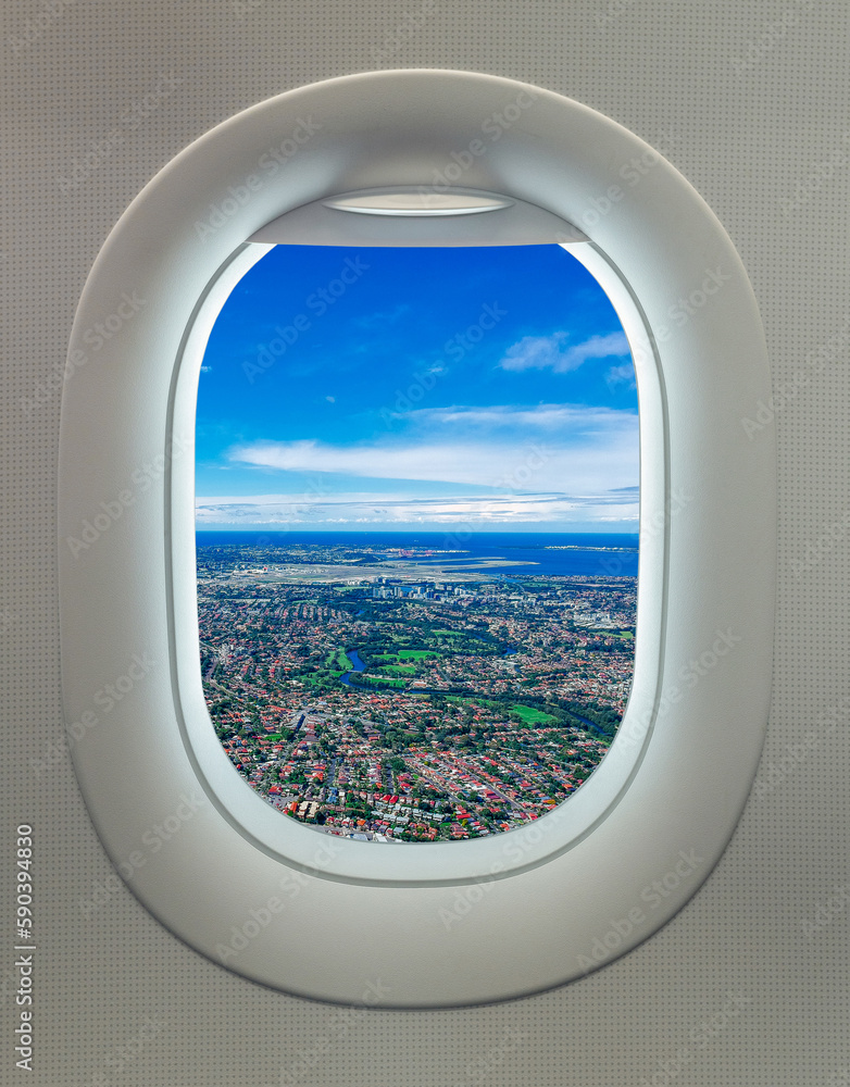 Fototapeta premium View from Airplane window over Sydney Suburbs houses building and apartments with orange roof tops rivers and parks NSW Australia