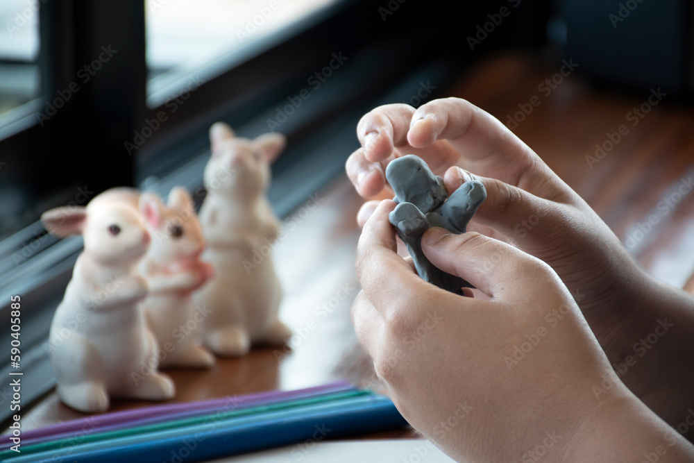 An autistic boy molding different shapes of colored plasticine prepared