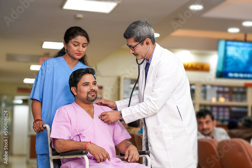 Indian male doctor checkup to patient with stethoscope on wheel chair.