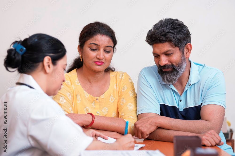 Indian female doctor writing prescription and discuss to couple. Indian female doctor writing prescription and discuss to couple.