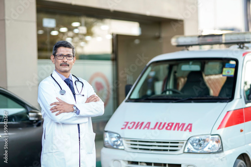 Confident indian male doctor standing at hospital