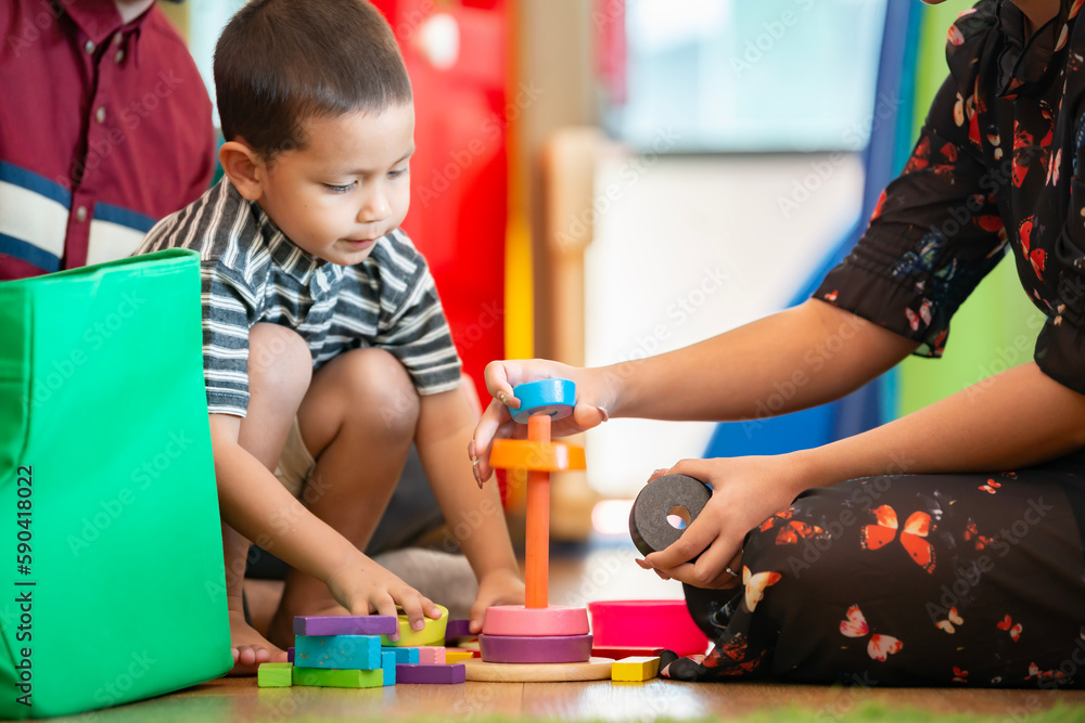 Kid with parents playing educational toys, arranging, sorting colors