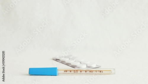 Medicine blisters pack falling down over thermometer