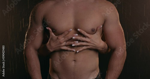 unrecognizable woman standing behind her strong muscular man and hugging him, touching his perfect body, slow motion closeup