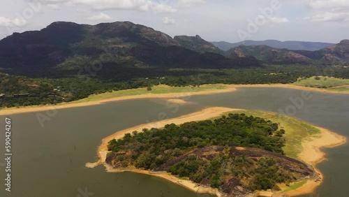 Tropical landscape: A lake in the middle of a forest against the background of mountains. Kandalama Reservoir in Sri Lanka. photo