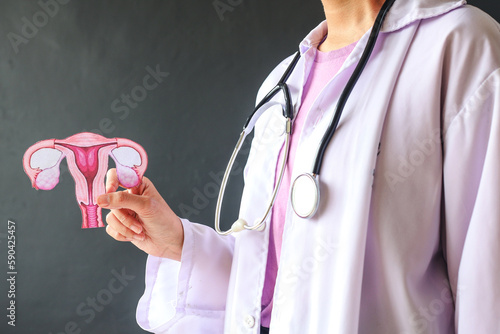 Doctor holds uterus shape to support cancer survivor. Ovarian Cancer month, cervical cancer day.  photo