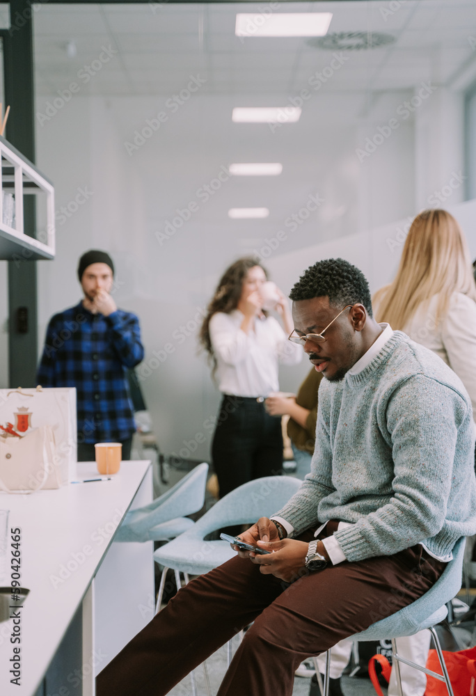 Fashionable black male business person relaxing in the kitchen at work