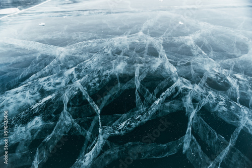 The space magical deep Baikal ice with cracks before your eyes. Close-up view