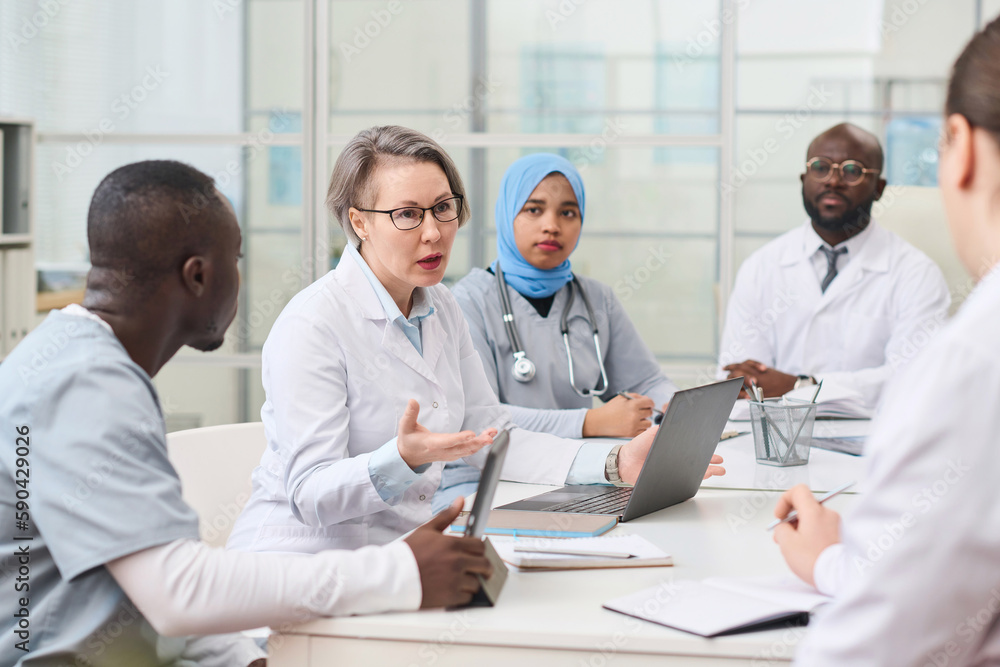 Fototapeta premium Group of doctors having meeting in office and discussing difficult disease of patient