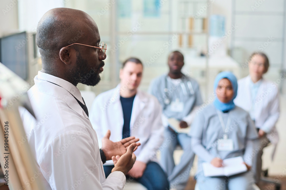 African American speaker talking to group of doctors during conference African American speaker talking to group of doctors during conference