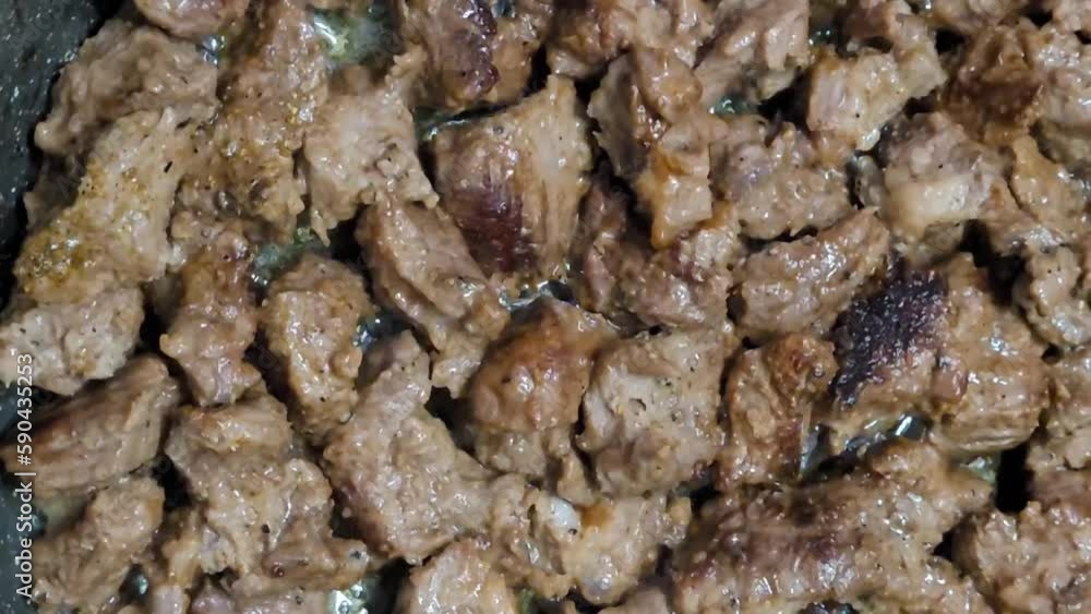 Beef is stewed in a frying pan. Close up Goulash. Horizontal video with pieces of veal. Traditional Hungarian dish. Beef is stewed in a frying pan. Close up Goulash. Horizontal video with pieces of veal. Traditional Hungarian dish.