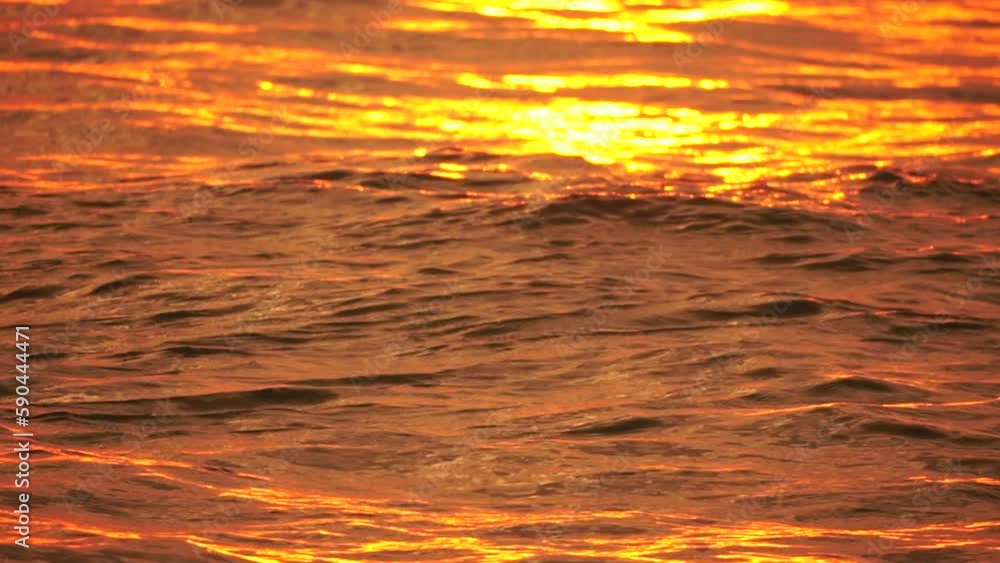 Blurred golden sea at sunset. The sun reflects and sparkles on the waves with bokeh, illuminating the golden sea. Holiday recreation concept. Abstract nautical summer ocean sunset nature background. Blurred golden sea at sunset. The sun reflects and sparkles on the waves with bokeh, illuminating the golden sea. Holiday recreation concept. Abstract nautical summer ocean sunset nature background.