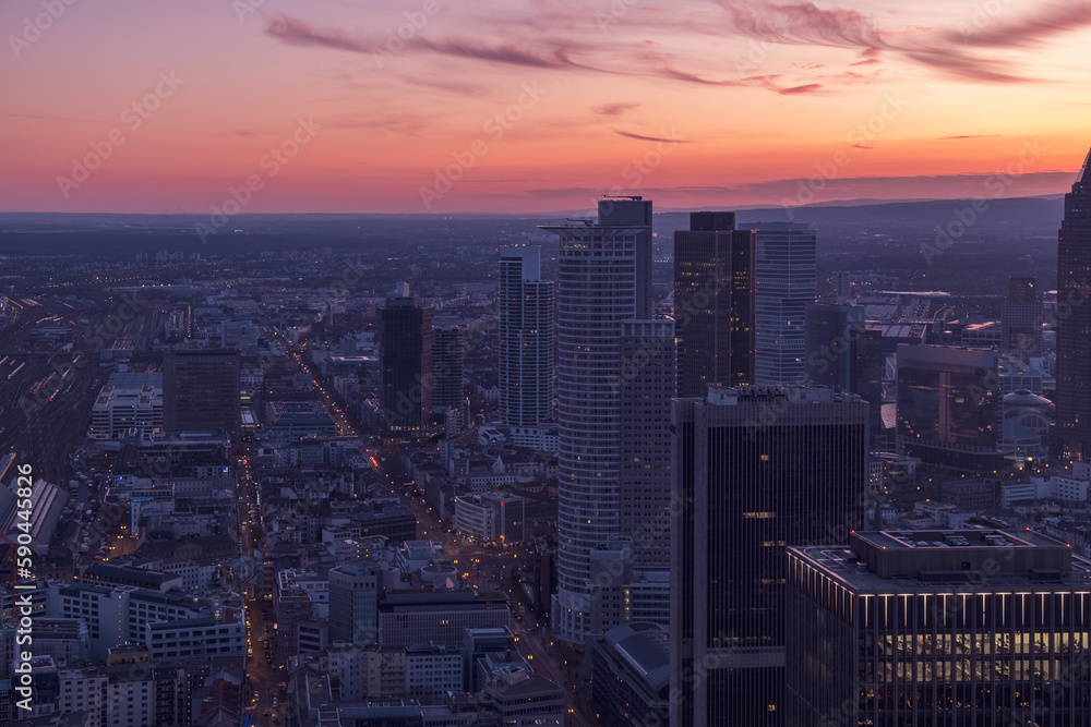 Urban centre at sunset with a pink dusk sky over the high-rises. Frankfurt at sunset with a purple-pink sky 