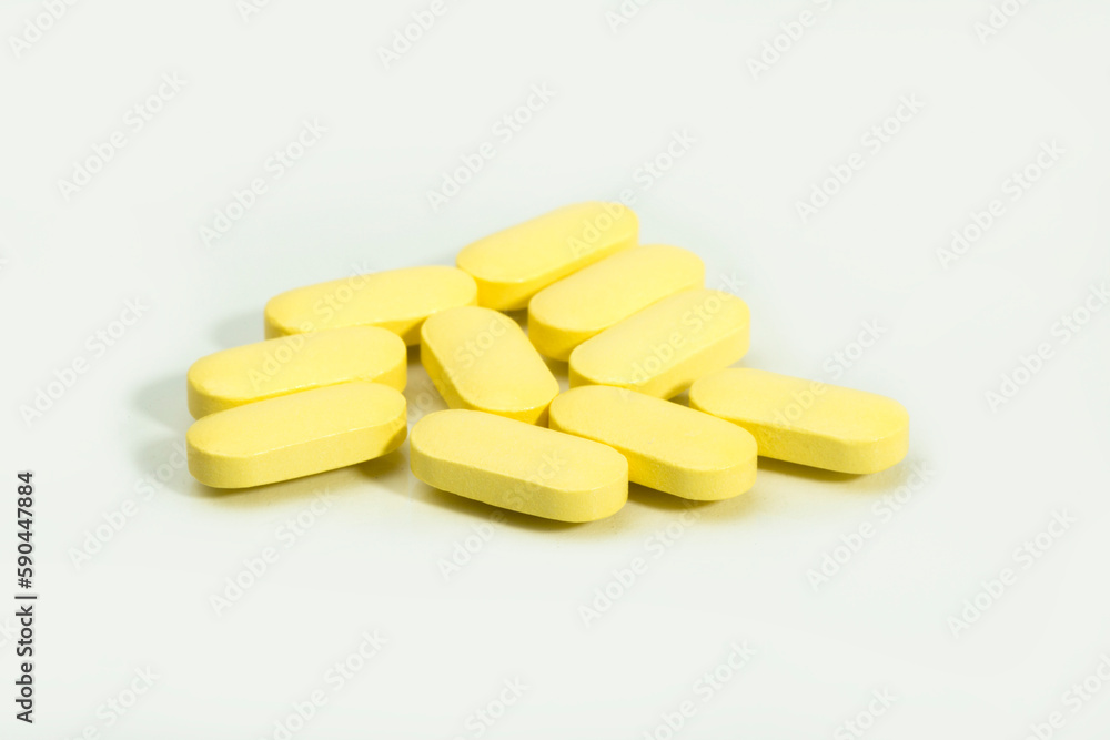 Close up shots of medicine tablets and capsules on white background. White and colored tablets placed in a group. Close up shots of medicine tablets and capsules on white background. White and colored tablets placed in a group.