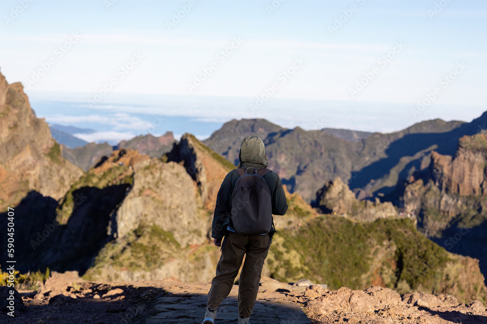 Traveling woman standing on the top of the mountain and watching beautiful view of majestic mountains