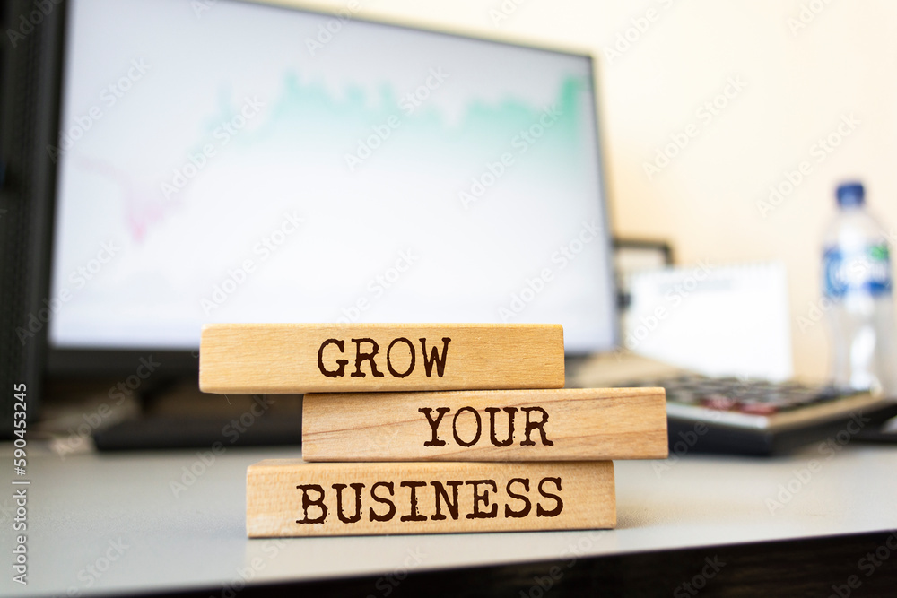 Naklejka premium Wooden blocks with words 'Grow your business'. Business concept