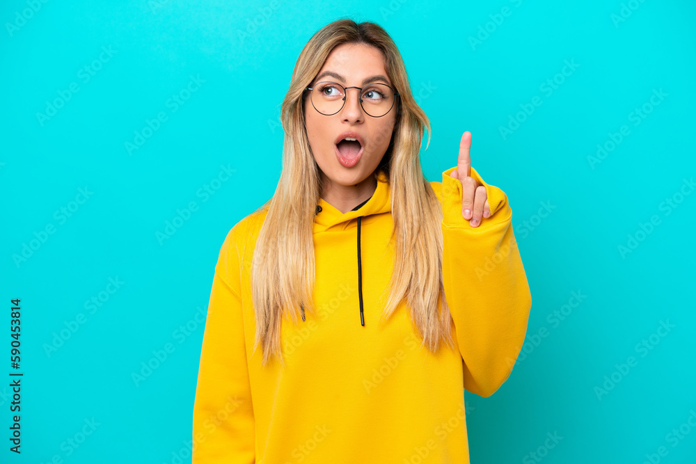 Young Uruguayan woman isolated on blue background thinking an idea pointing the finger up Young Uruguayan woman isolated on blue background thinking an idea pointing the finger up