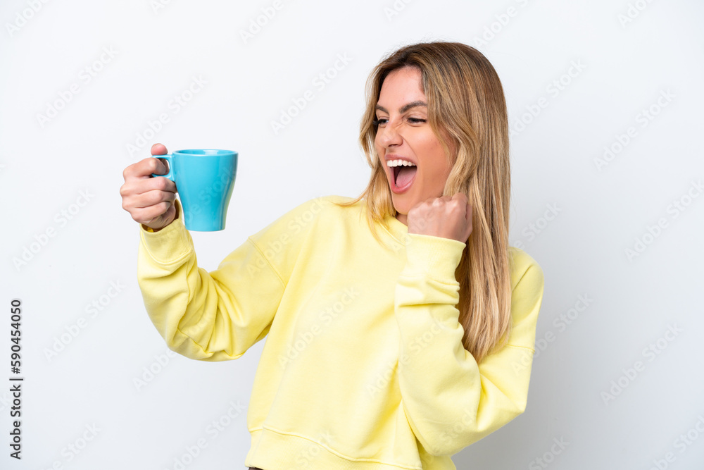 Young Uruguayan woman holding cup of coffee isolated on white background celebrating a victory Young Uruguayan woman holding cup of coffee isolated on white background celebrating a victory