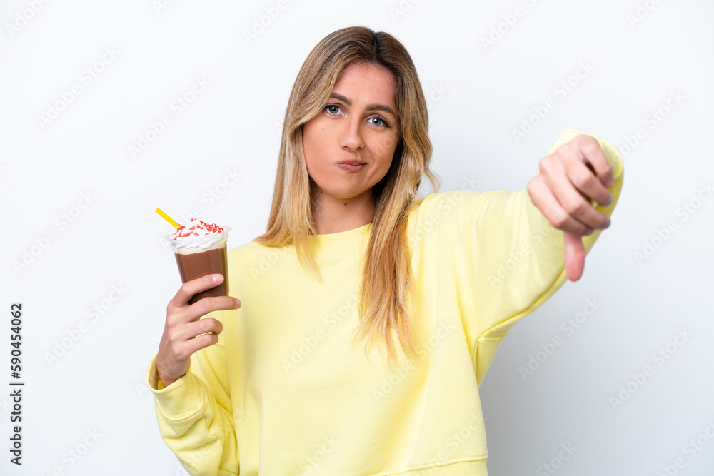 Young Uruguayan woman holding Frappuccino isolated on white background showing thumb down with negative expression Young Uruguayan woman holding Frappuccino isolated on white background showing thumb down with negative expression