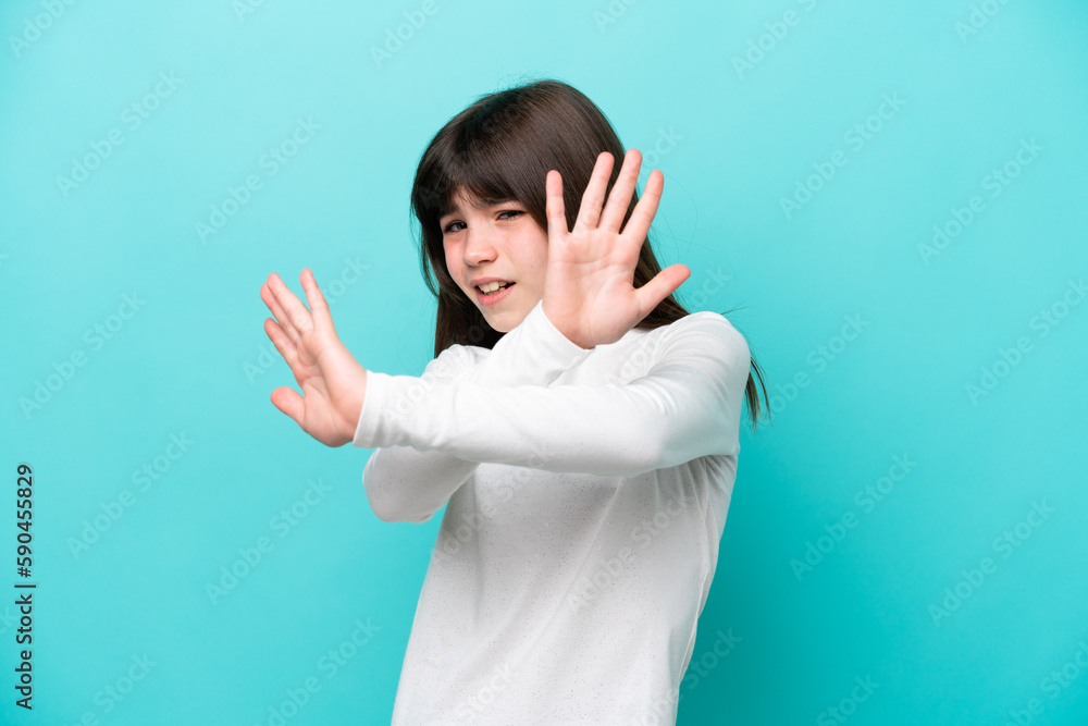Fototapeta premium Little caucasian girl isolated on blue background nervous stretching hands to the front