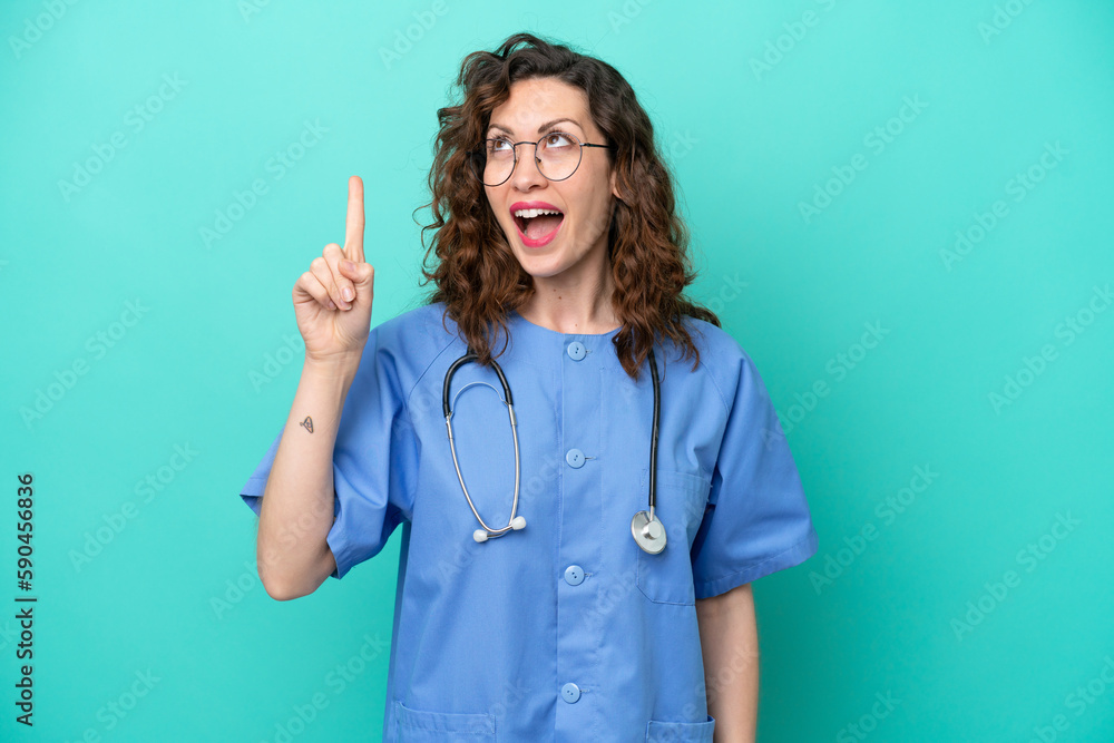 Young nurse caucasian woman isolated on blue background intending to realizes the solution while lifting a finger up Young nurse caucasian woman isolated on blue background intending to realizes the solution while lifting a finger up