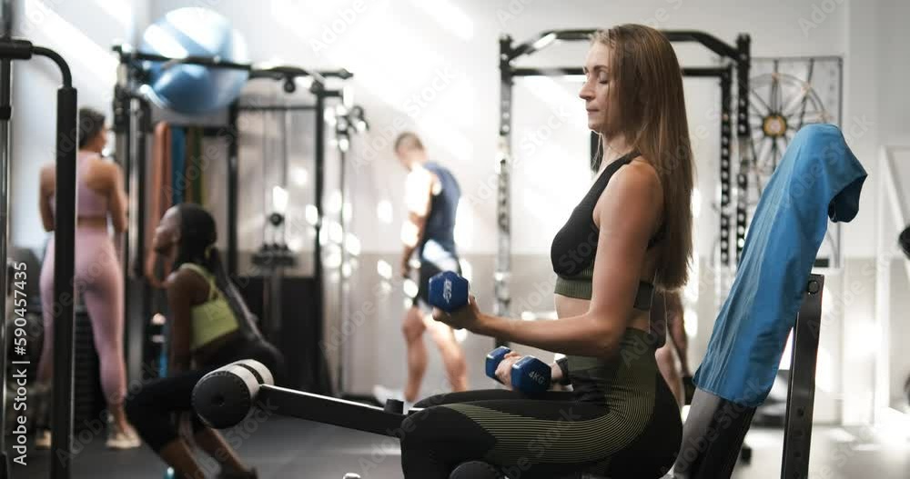 Woman exercising with dumbbells in the gym. Woman exercising with dumbbells in the gym.