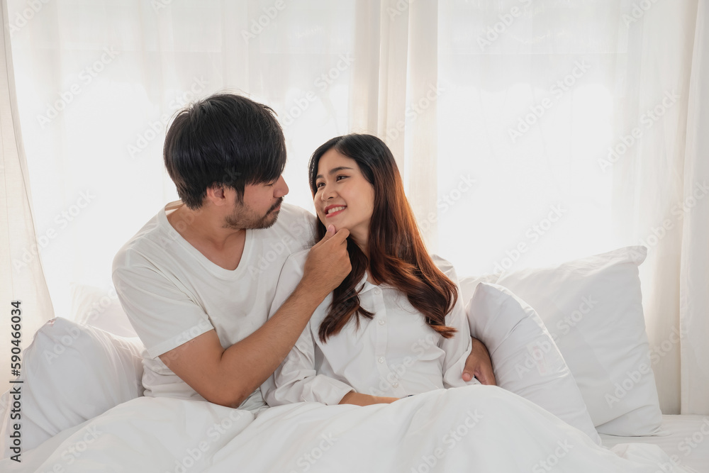 Happy young asian couple embracing, teasing, playing cheerfully in bed at home, romantic time to enhance family bonding. family concept. Happy young asian couple embracing, teasing, playing cheerfully in bed at home, romantic time to enhance family bonding. family concept.